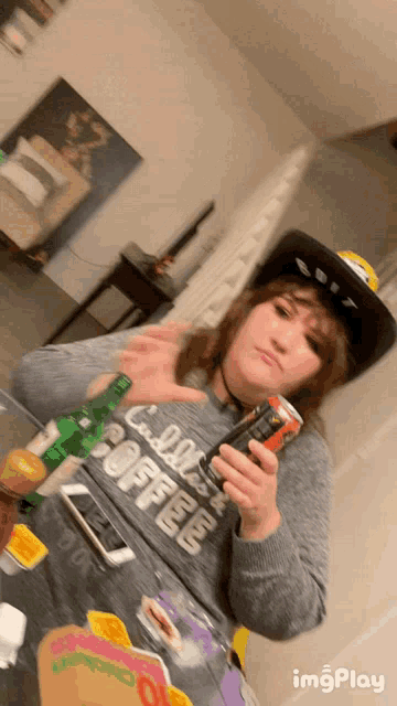 a woman wearing a shirt that says " cold brew coffee " is holding a can of soda