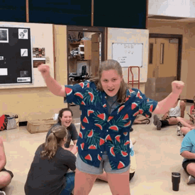 a girl in a watermelon shirt is standing in a room