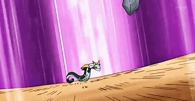 a cartoon dragon is standing on top of a sandy hill .