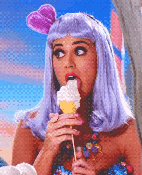 a woman in a purple wig is eating ice cream
