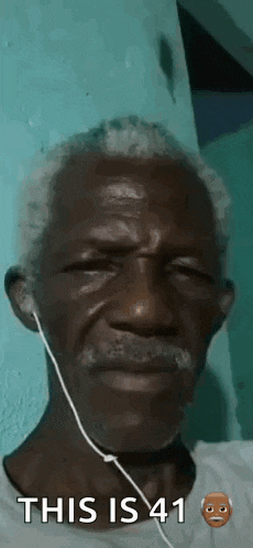 a man with a beard and ear buds is wearing headphones .