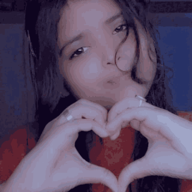 a girl making a heart with her hands