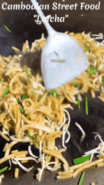 a spoon is being used to stir noodles in a pan ..