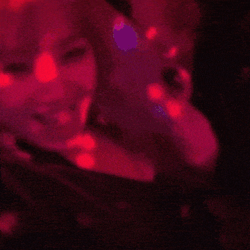 a woman is smiling in a red light