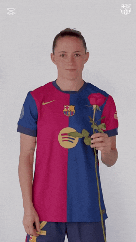 a woman wearing a barcelona jersey is holding a rose