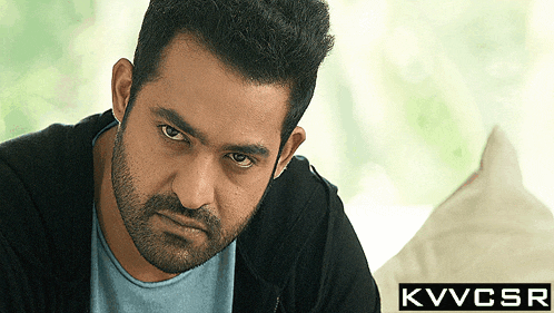 a man with a beard is looking at the camera with a kvvcsr logo in the corner