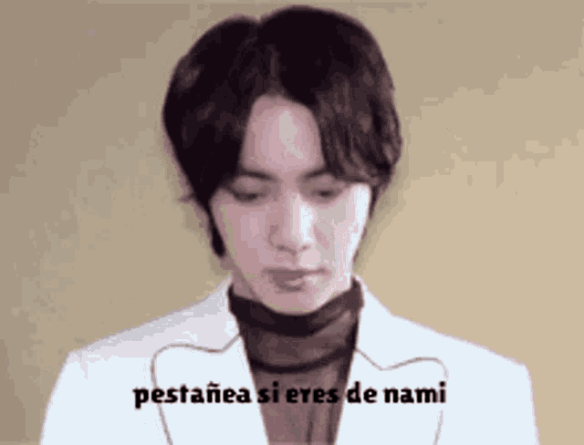 a man wearing a white jacket and a black turtleneck says pestania si eres de nami in spanish