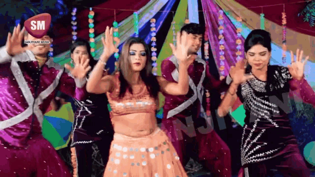 a group of people are dancing in front of a sign that says sm on it