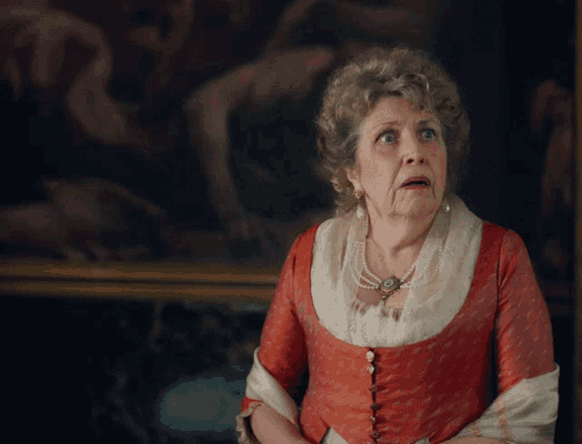 a woman in a red dress stands in front of a painting with a surprised look on her face
