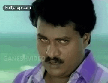 a man with a mustache is making a funny face .
