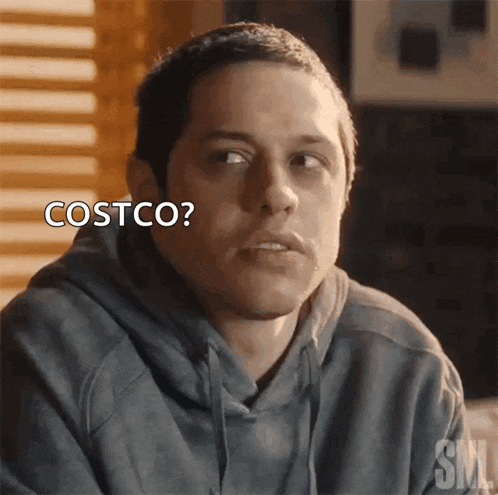 a man in a hoodie says costco while looking at the camera