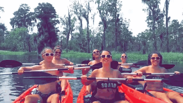 a group of women in kayaks wearing sunglasses and a squad shirt