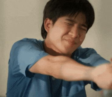 a man in a blue shirt is making a funny face with his eyes closed