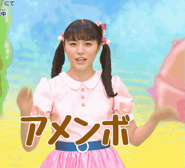 a girl in a pink dress with a blue belt stands in front of a sign that says " amenbo "