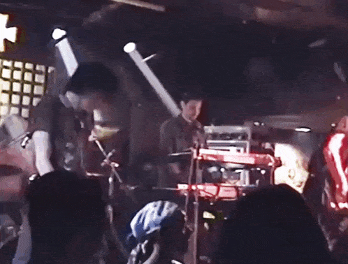 a man in a black shirt with a skull on it is standing on a stage