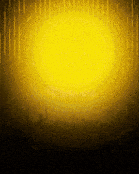 a crowd of people in front of a yellow light