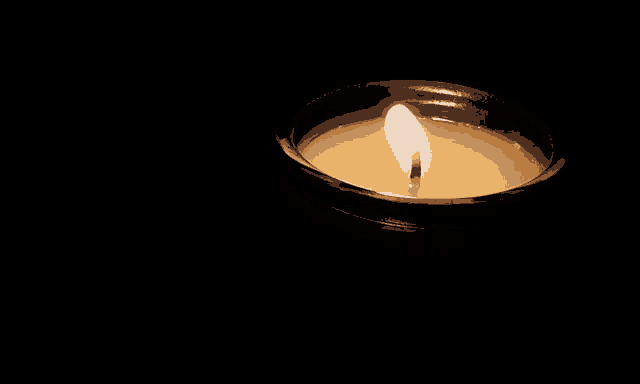 a candle is lit in a dark room