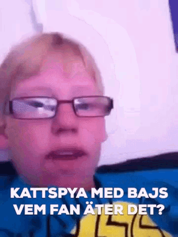 a boy wearing glasses and a yellow shirt says kattspya med bajs vem fan ater det ?
