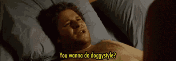 a shirtless man is laying on a bed and says " you wanna do doggy style "
