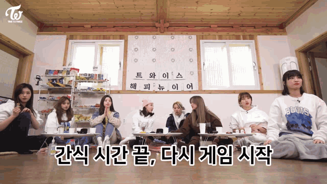 a group of girls sitting around a table with a sign that says twice