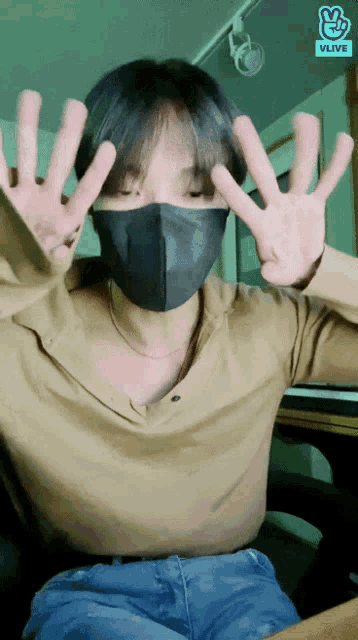a man wearing a mask and a vlive logo on his shirt