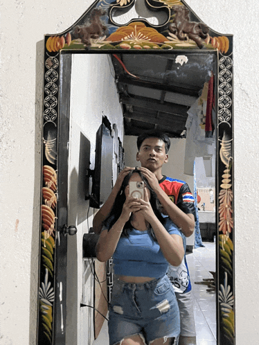 a man and woman are taking a picture in a mirror