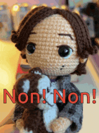 a crocheted doll is holding a stuffed animal with the words non non written in red