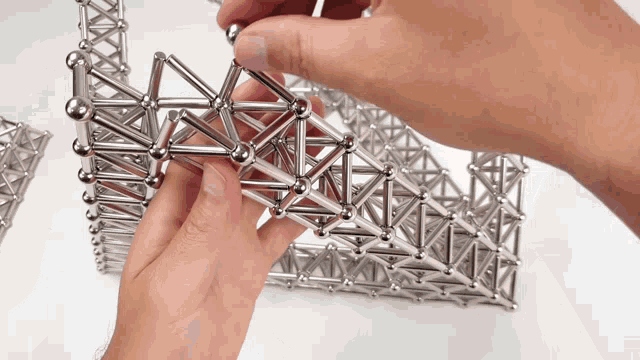 a person is playing with a magnetic toy that looks like a bridge