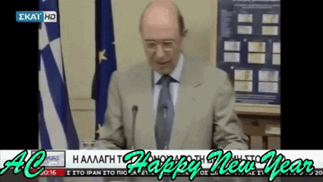 a man in a suit and tie is giving a speech in front of a microphone with the words happy new year written in green