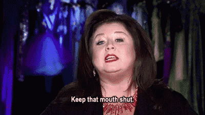 a woman is saying `` keep that mouth shut '' while standing in front of a closet .