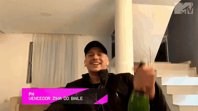 a man is holding a bottle with the name pk vencedor zika do baile on it