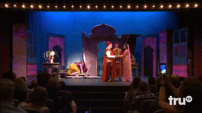 a man in a genie costume is dancing on a stage in front of a sign that says tru