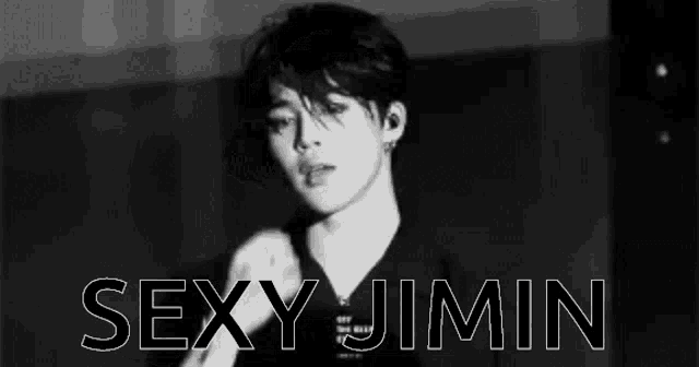 a black and white photo of a young man in a black shirt with the words `` sexy jimin '' written above him .