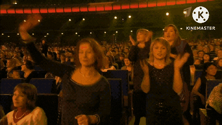 a crowd of people applauding in front of a sign that says " kinemaster "
