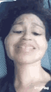 a close up of a woman making a face with her tongue out .