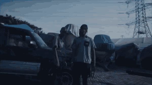 a man pointing a gun at another man while standing next to a car