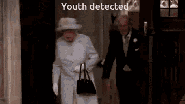 queen elizabeth wearing a white coat and hat is walking with a man in a suit and the words youth detected above her