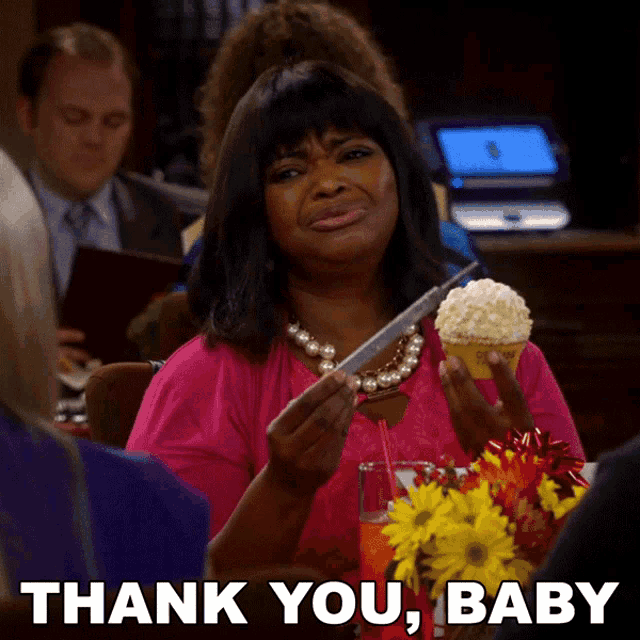 a woman in a pink shirt is holding a cupcake and a syringe and says " thank you baby "