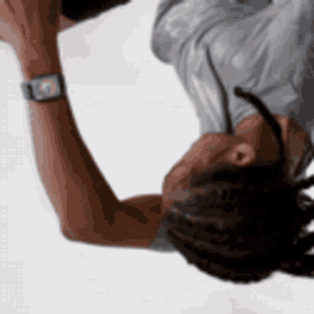a woman wearing an apple watch is laying upside down