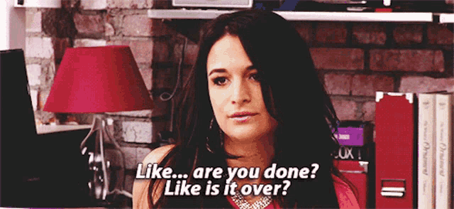 a woman says " like are you done like is it over " in front of a red lamp