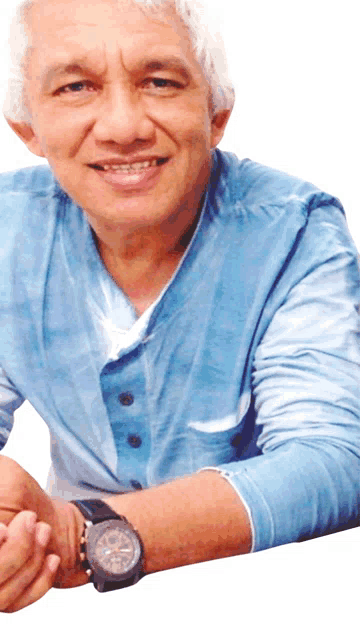 a man wearing a blue shirt has a watch on his wrist that shows the time as 4:20