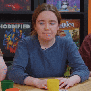 a woman sits at a table in front of a sign that says horrificed