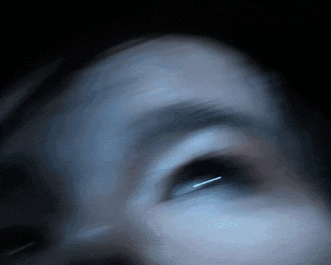 a blurry picture of a person 's face with a blue eye