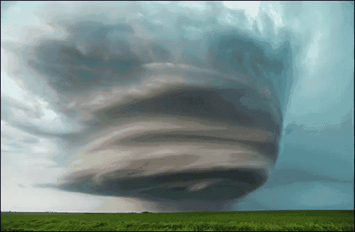 a large tornado is moving through a field of grass