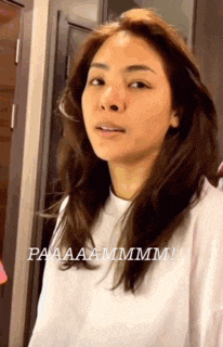 a woman with long brown hair is wearing a white shirt .