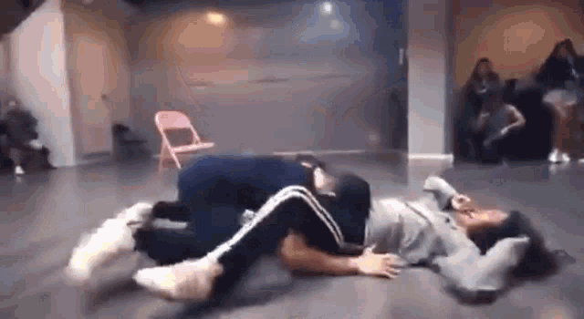 a man is laying on top of a woman on the floor in a room .