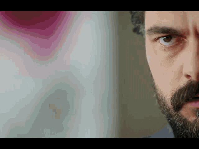 a close up of a man 's eye with a beard
