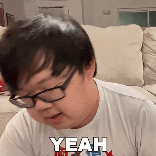 a man wearing glasses and a white shirt with the word yeah on it