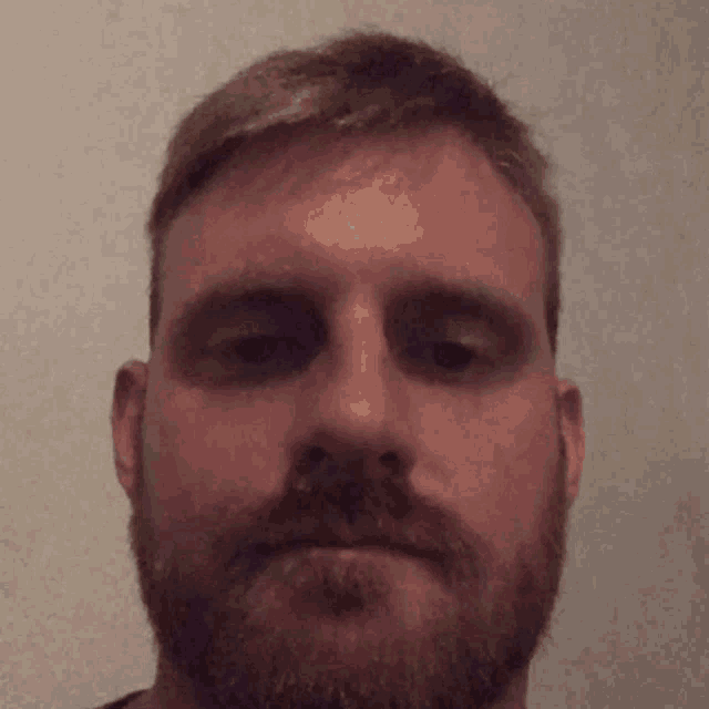 a man with a beard looks up at something