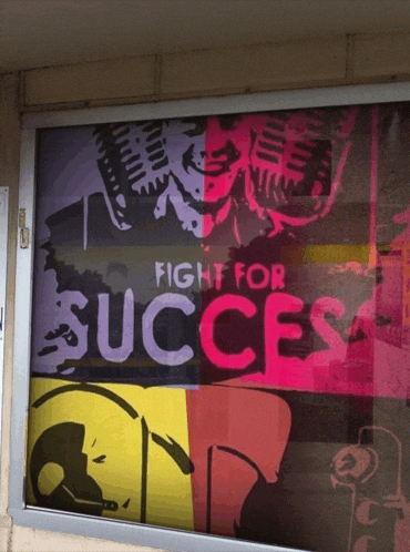a window with a poster that says fight for success on it